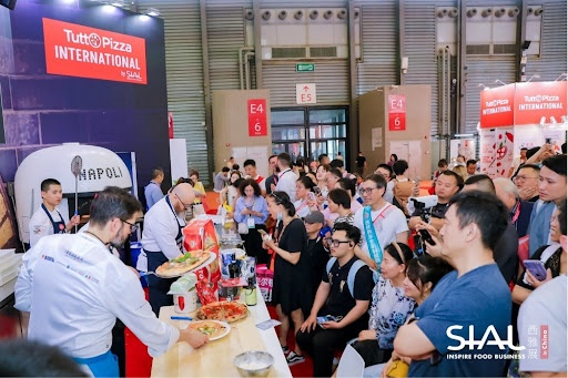 <img src="sial-china-tuttopizza-event.jpg" alt="Live pizza cooking demonstration at TuttoPizza International booth during SIAL China exhibition">