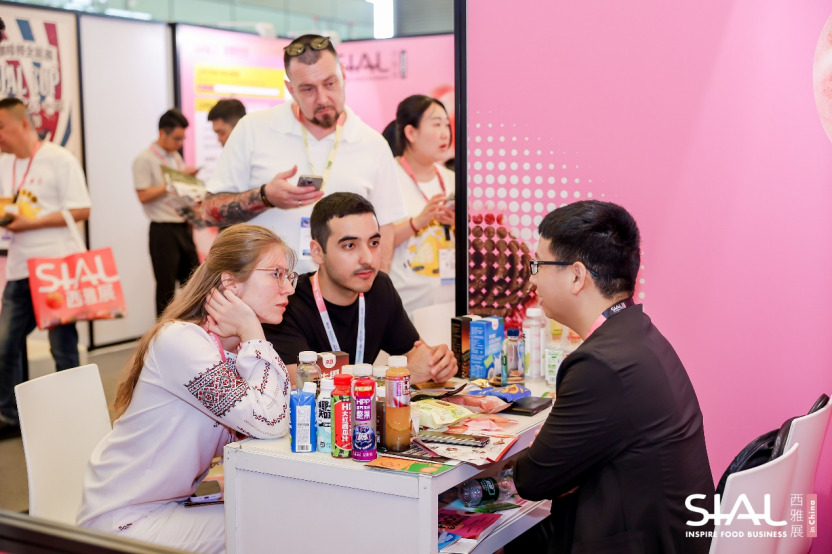 International buyers discussing food products at SIAL China exhibitor booth