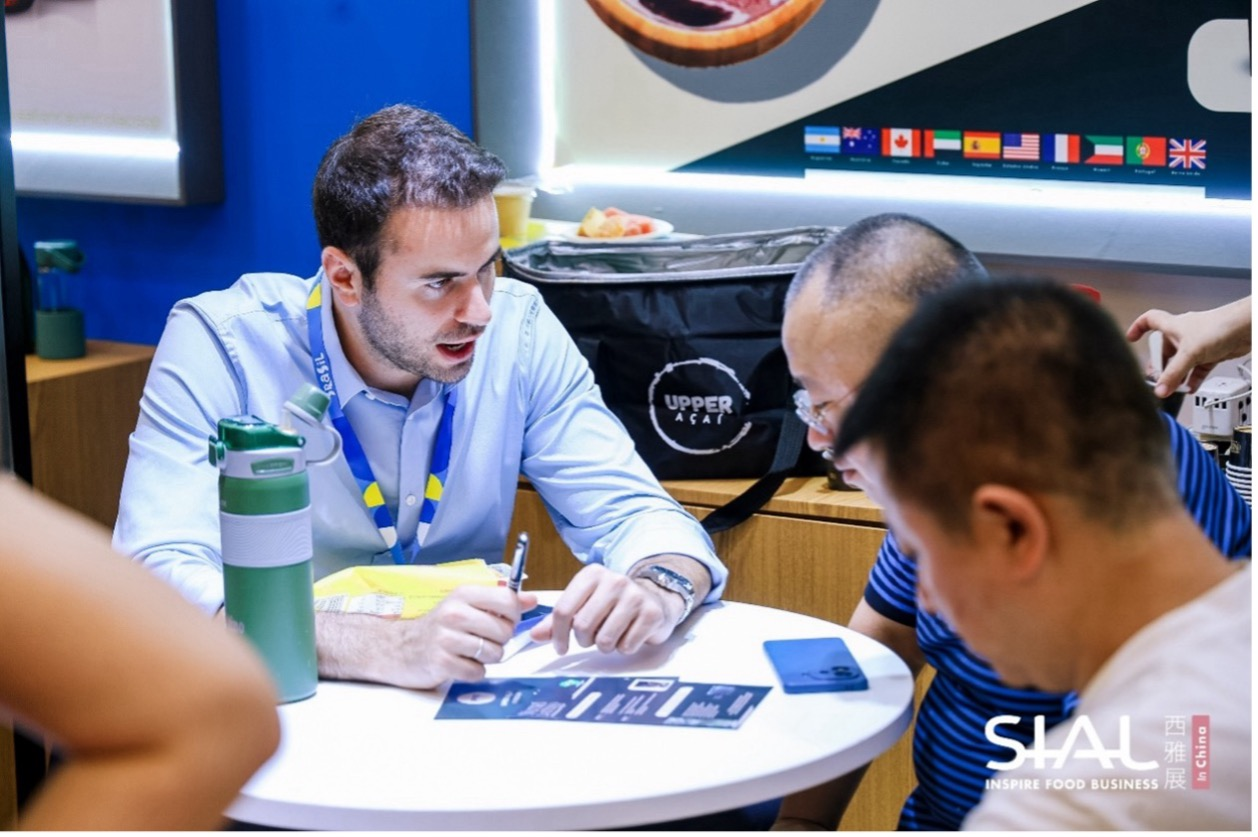 Foreign exhibitor with Brasil lanyard conducting B2B business matchmaking session at SIAL
