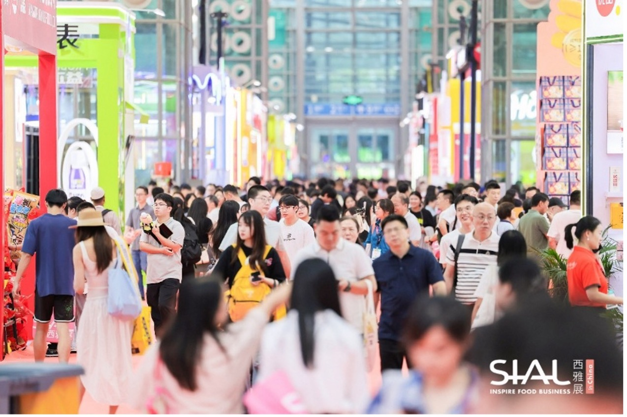 Dense crowd of professional visitors walking along the main aisle at SIAL food expo