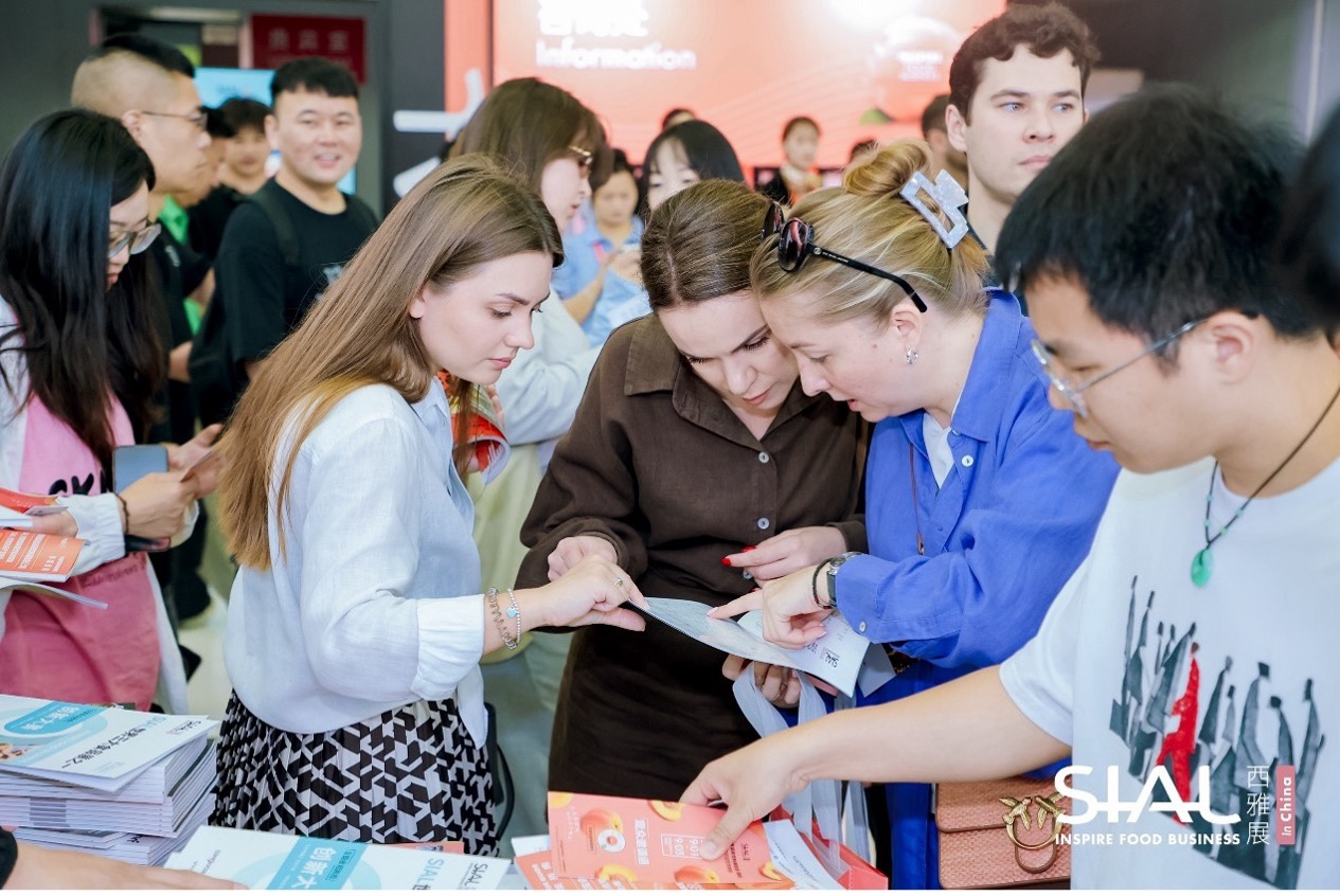 Foreign attendees looking at guide brochures near the SIAL information desk