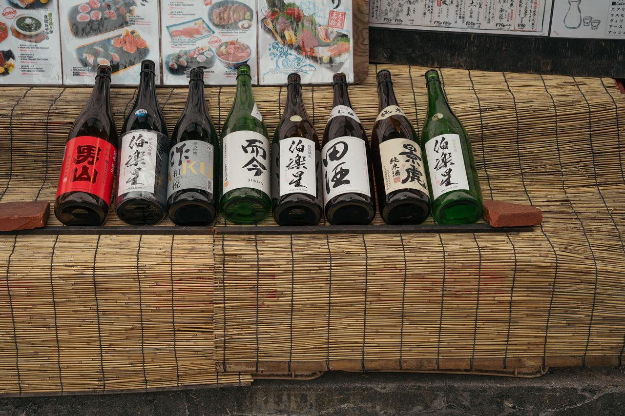 Various sake bottles on bamboo mat in Tokyo, showcasing Japanese culture.