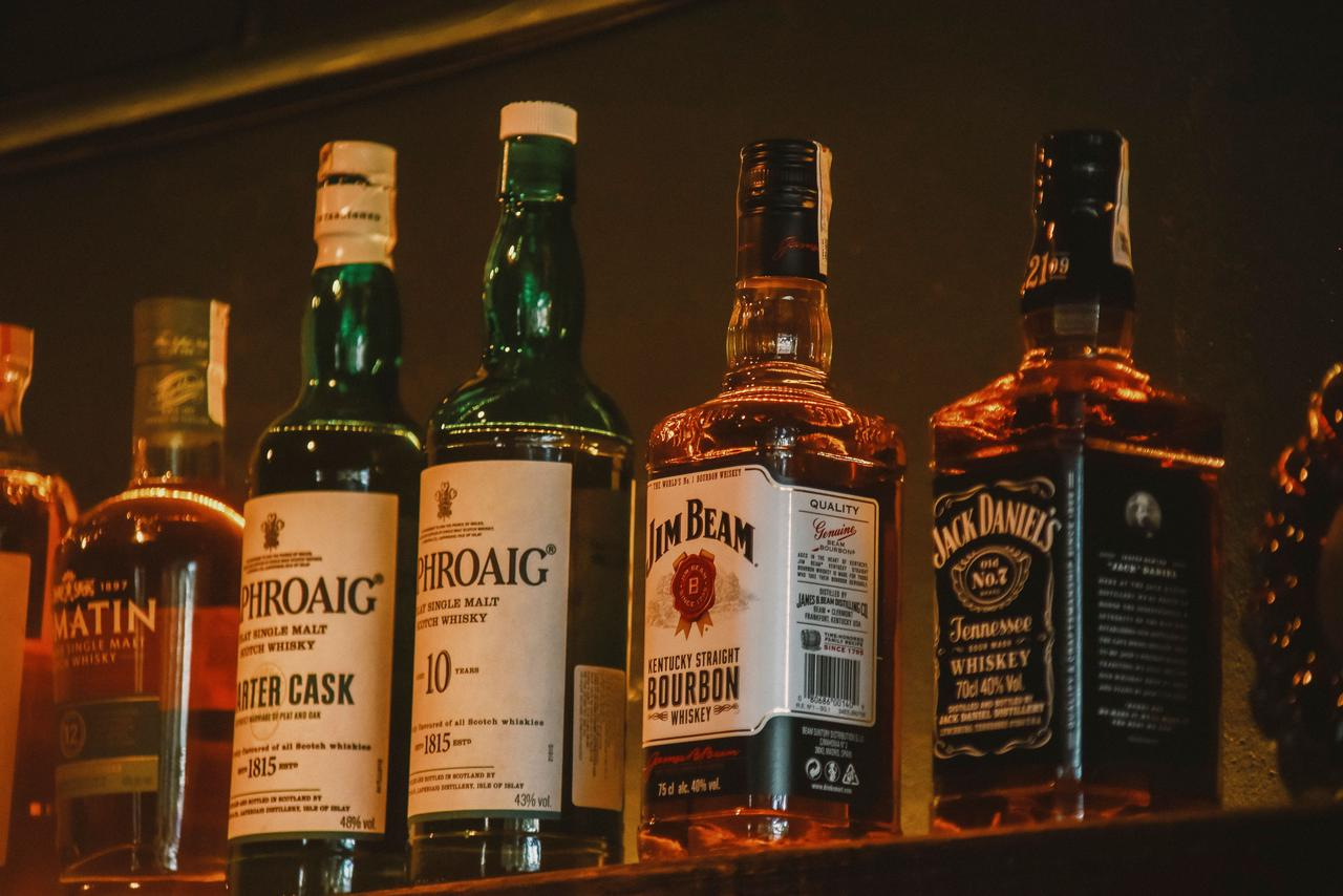A selection of premium whiskey brands elegantly arranged on a dimly lit display shelf