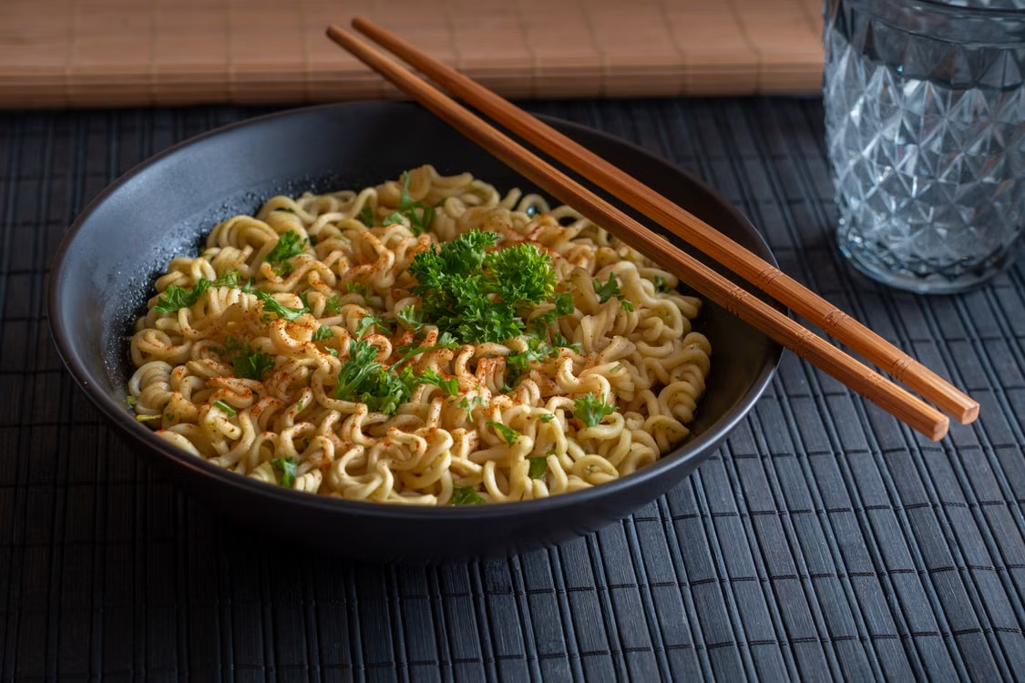 Delicious bowl of spicy instant noodles garnished with parsley, perfect for a quick meal